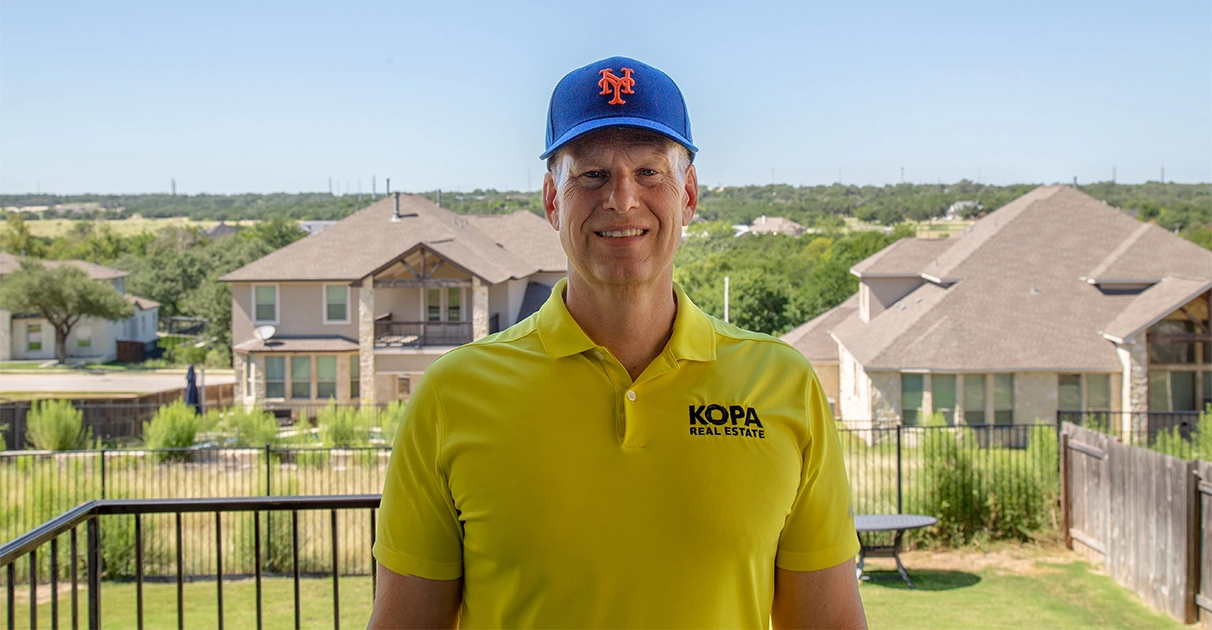 Eric wearing a blue New York Mets baseball hat with bright orange 