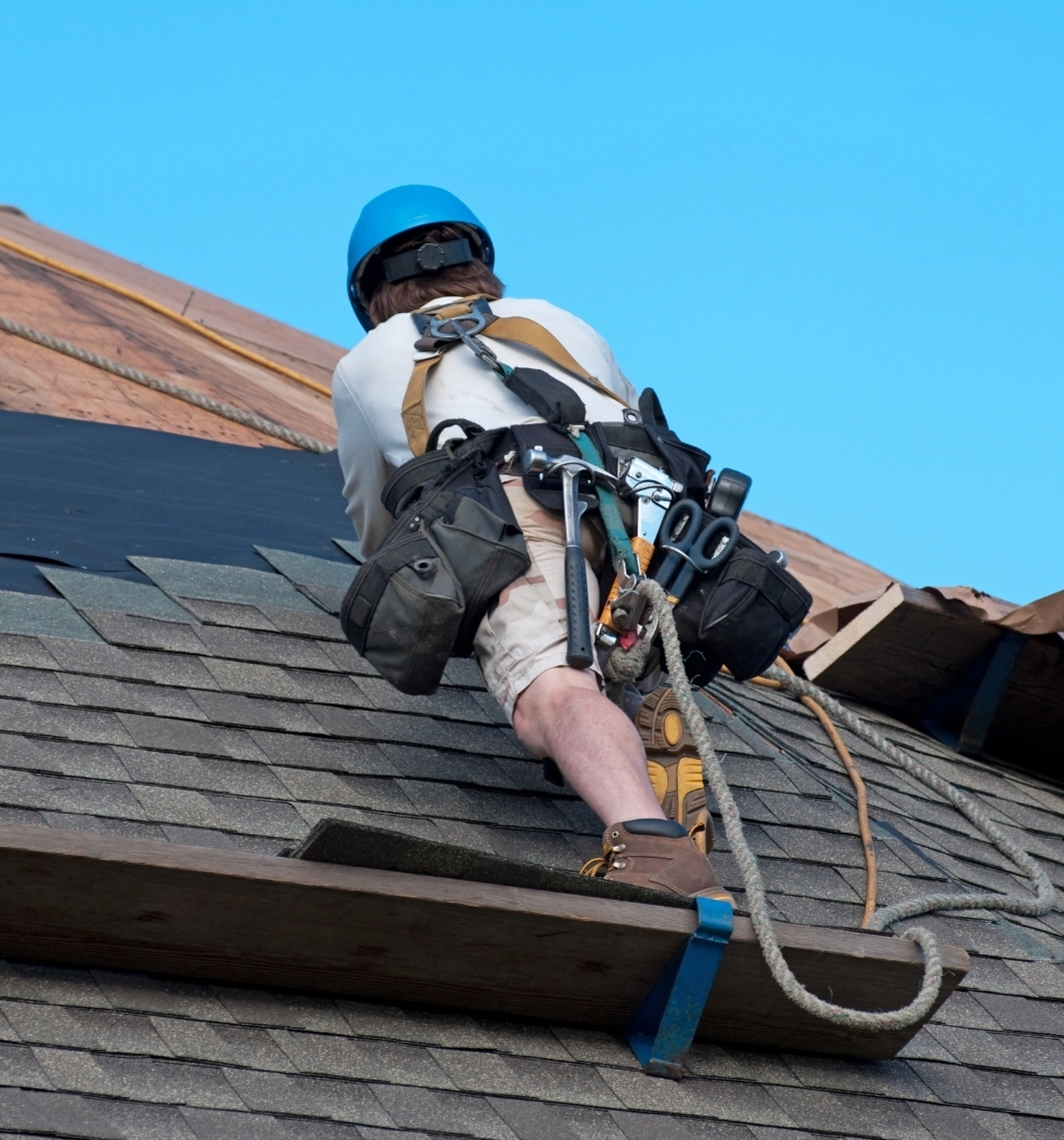 Contractor repairing a roof with new shingles in Austin, Texas home.
